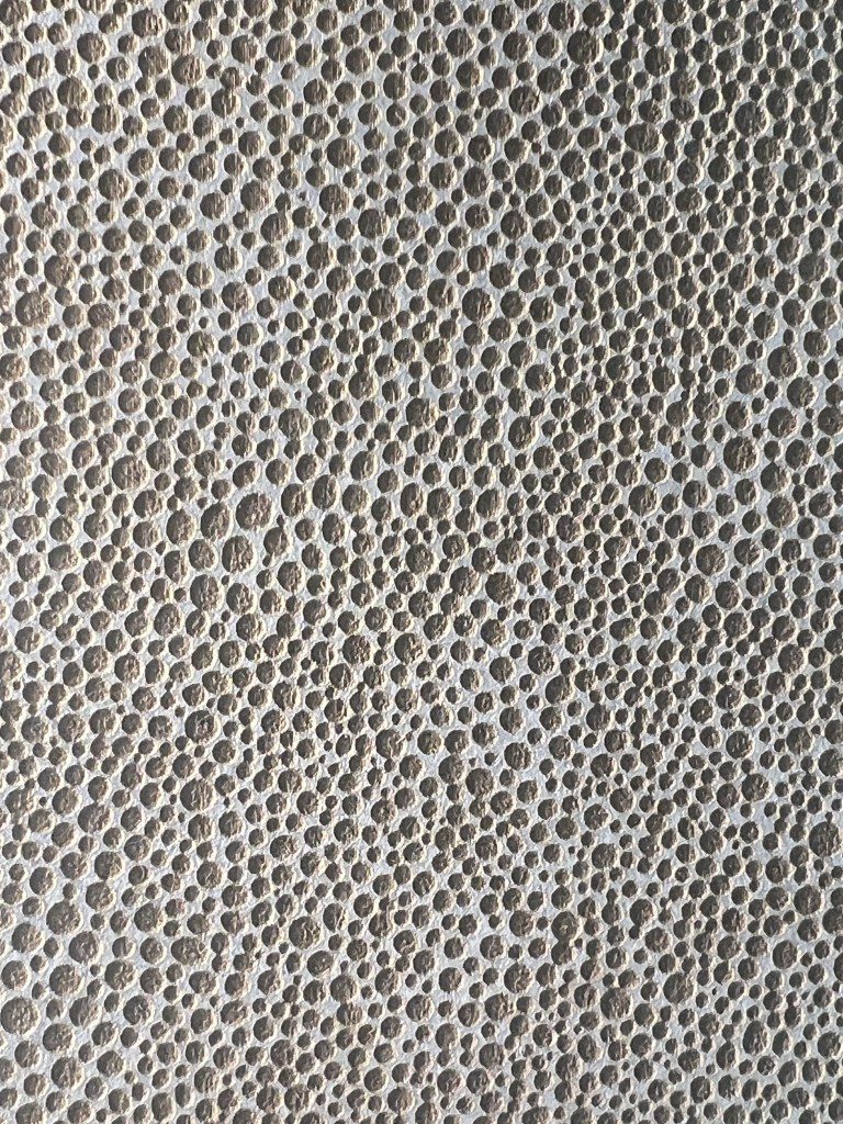 Close-up of a textured surface with numerous small, round holes.
