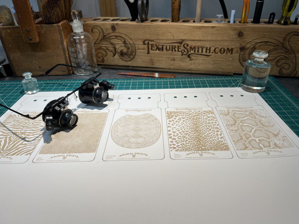 Three antique fishing reels and four vintage fishing license cards on a table.