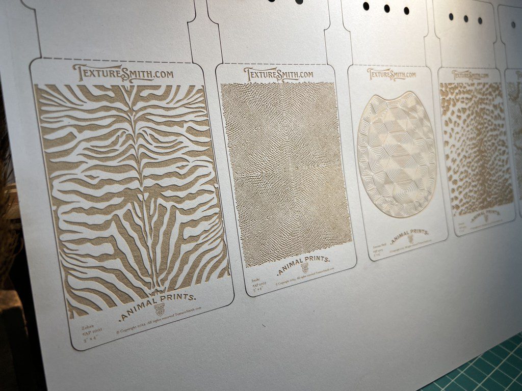 Three decorative wallpaper samples with distinct patterns displayed on a wall.