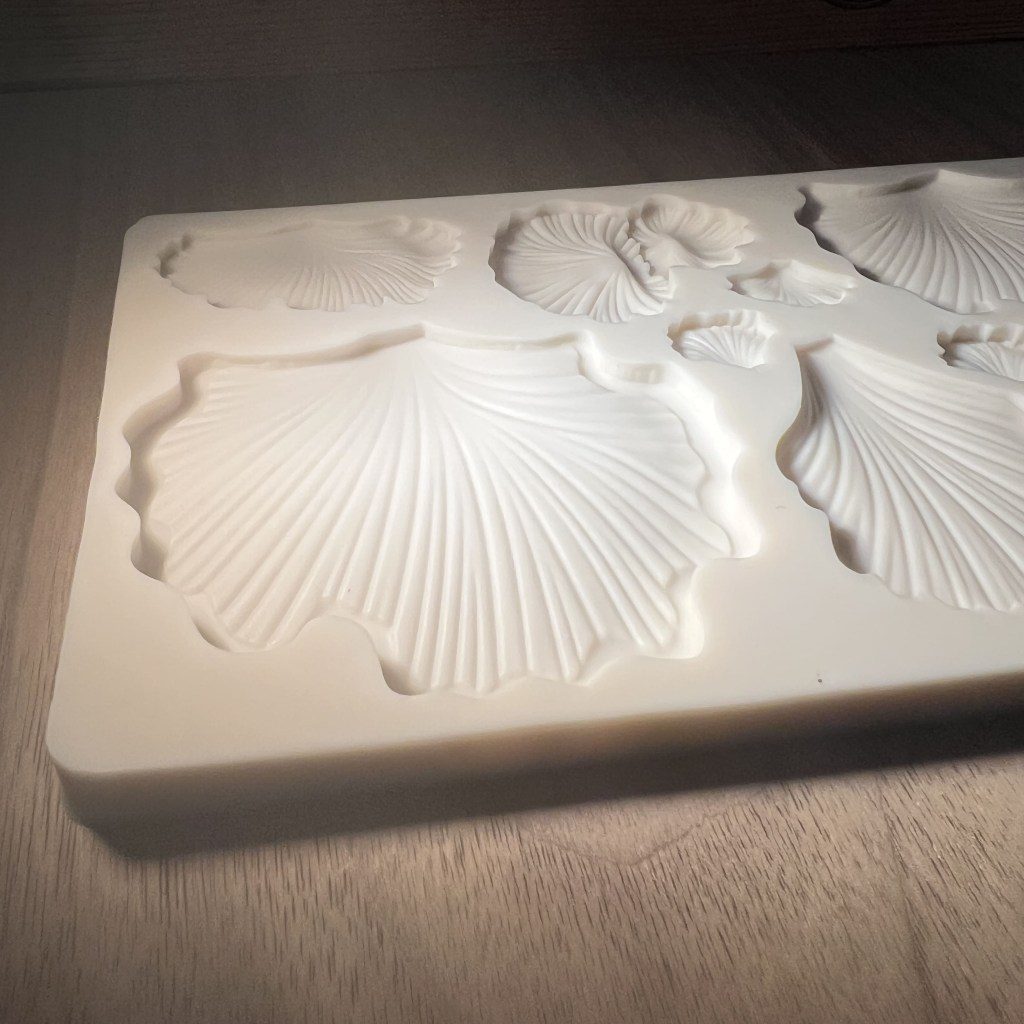 Intricately carved white stone slab with floral and leaf patterns.