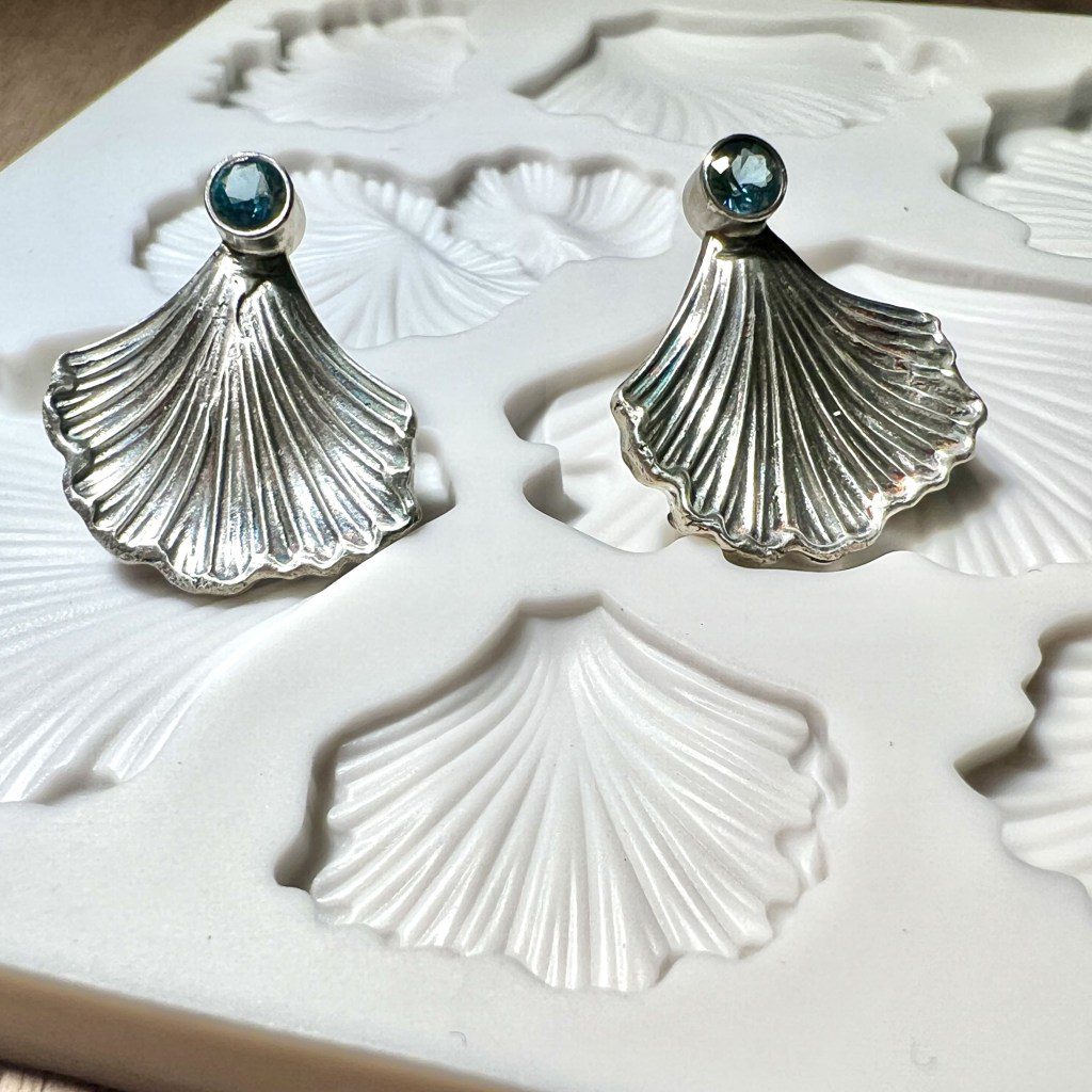 Elegant silver shell-shaped earrings with pearl studs.