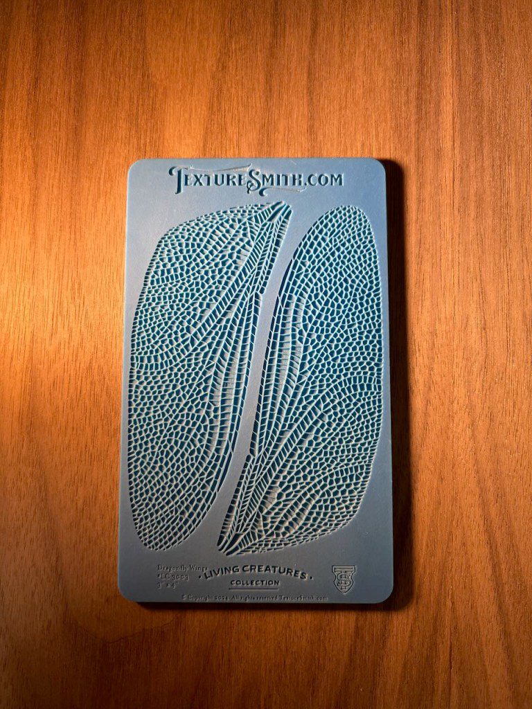 Close-up of a textured blue card on a wooden surface.