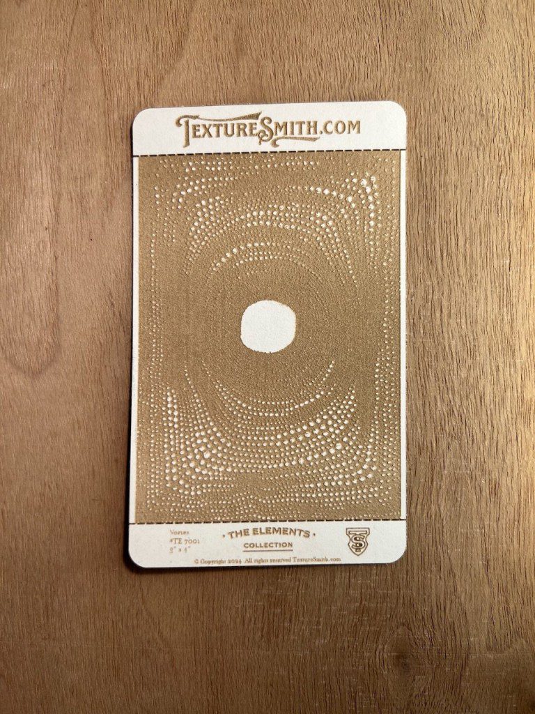 Gold stencil template with geometric patterns on wood.