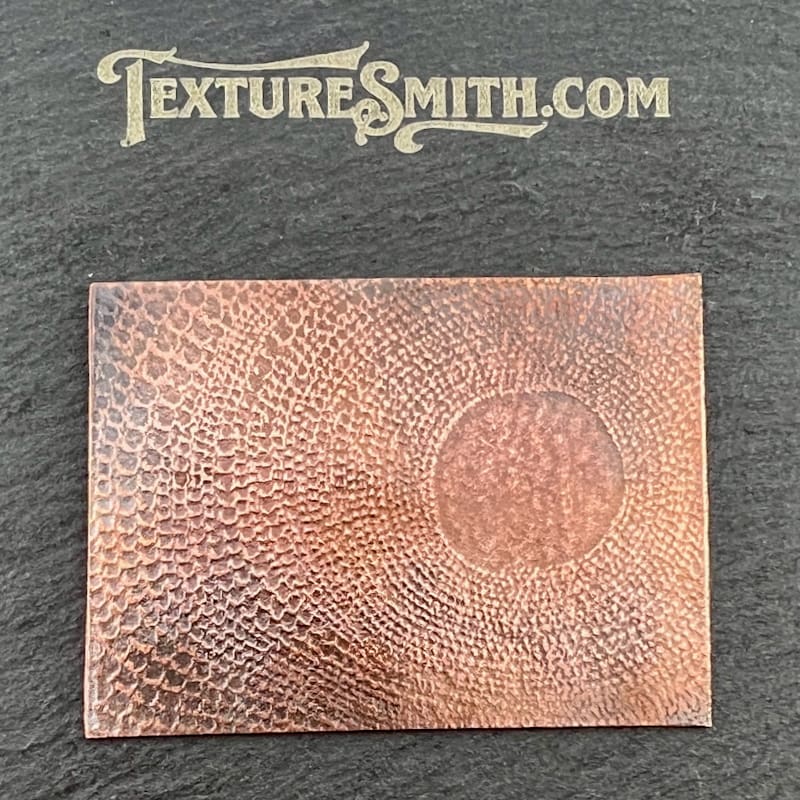 A leather piece embossed with a pumpkin design and textured surface.