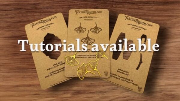 Three laser-cut wooden earrings on display cards.