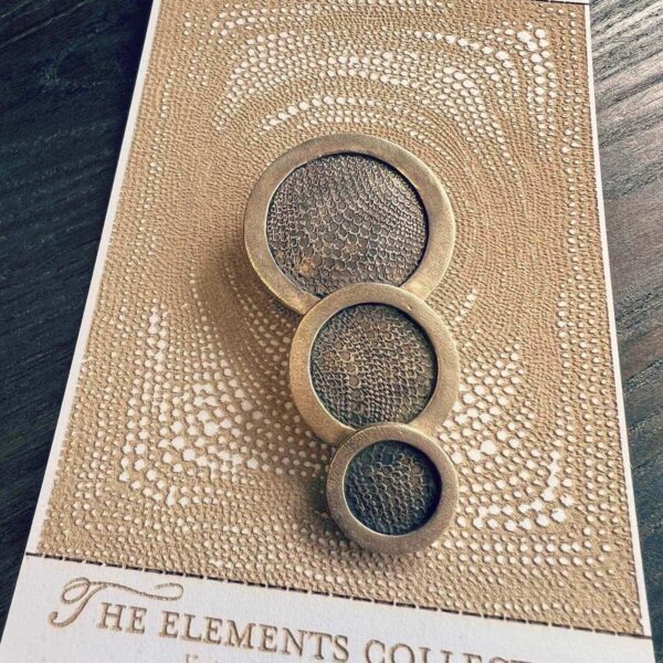 Three circular mesh screens on a textured brown surface labeled 'The Elements Collection'.