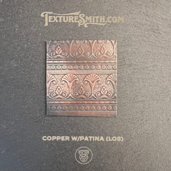 Intricate copper panel with ornamental patterns on a textured background.
