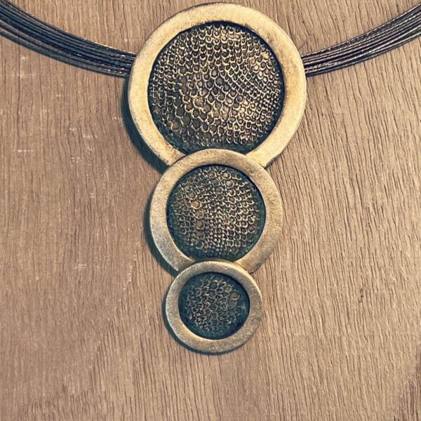 Three circular metallic mesh rings mounted on a wooden surface.