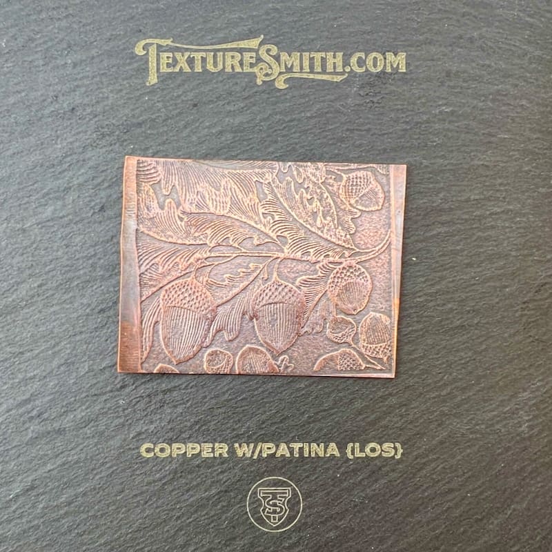 Copper plate with embossed leaf design and patina finish.