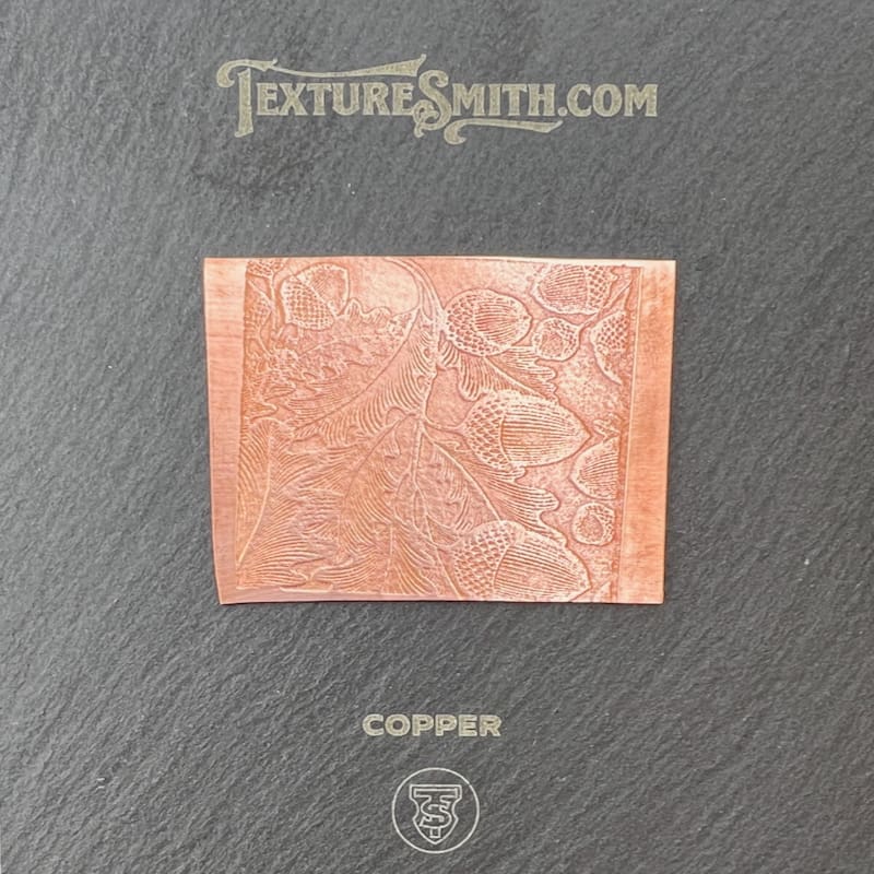 Close-up of a textured copper plate with intricate engravings.