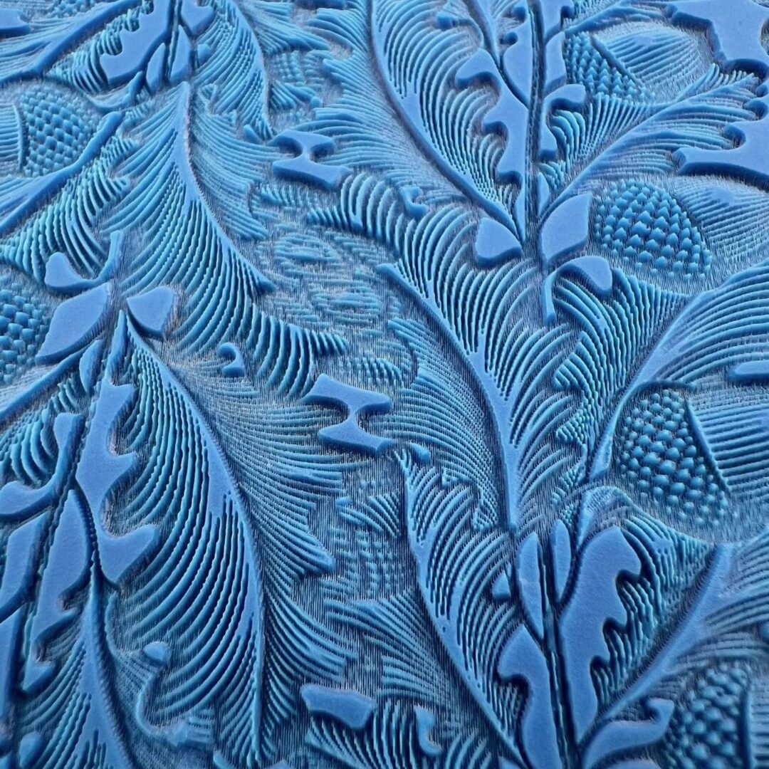 Intricate blue embossed floral pattern on a textured surface.
