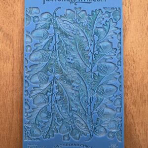 Embossed blue card with intricate floral and leaf pattern design.