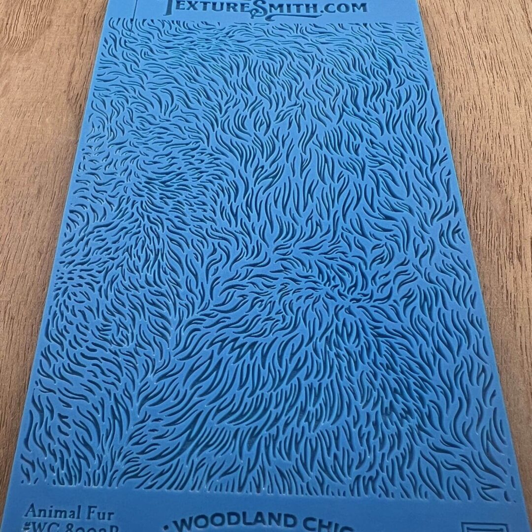 Blue textured mat with intricate swirl patterns on a wooden surface.