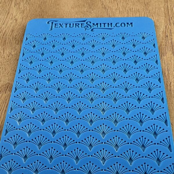 Blue crocheted or knitted fabric with a textured pattern and holes.