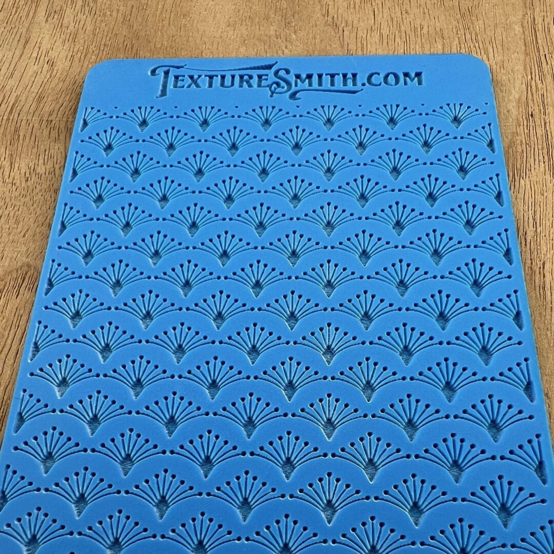 Blue crocheted or knitted fabric with a textured pattern and holes.