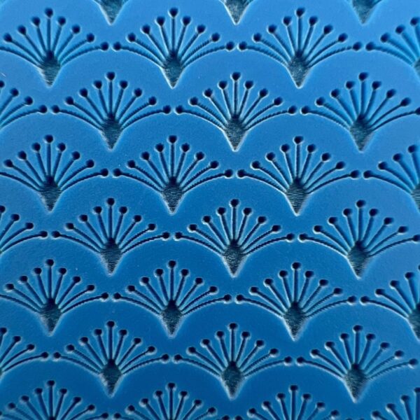 Blue wall with repeating fan-shaped embossed pattern.