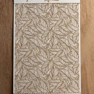 A notebook with a detailed leaf pattern cover resting on a wooden surface.