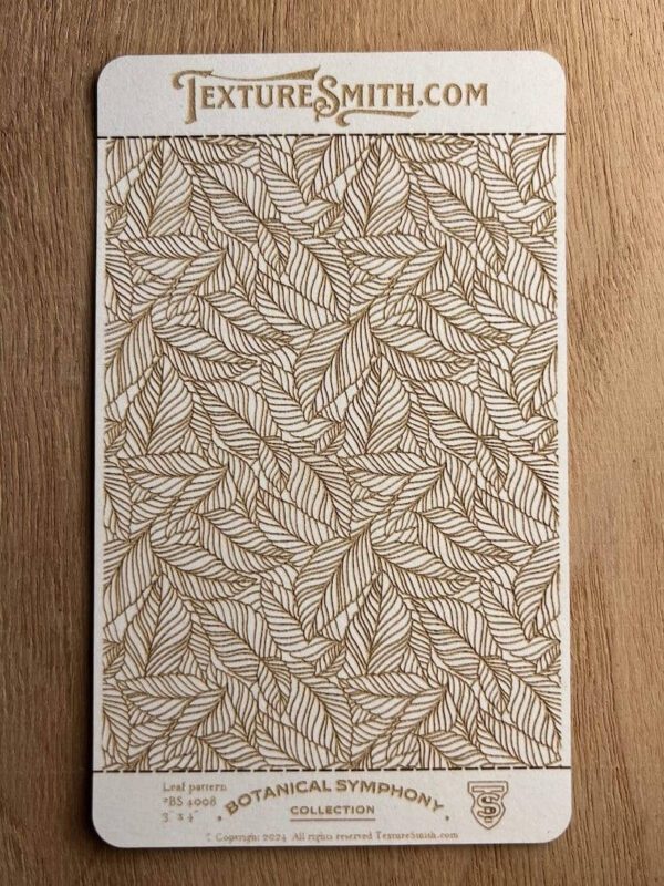 A notebook with a detailed leaf pattern cover resting on a wooden surface.