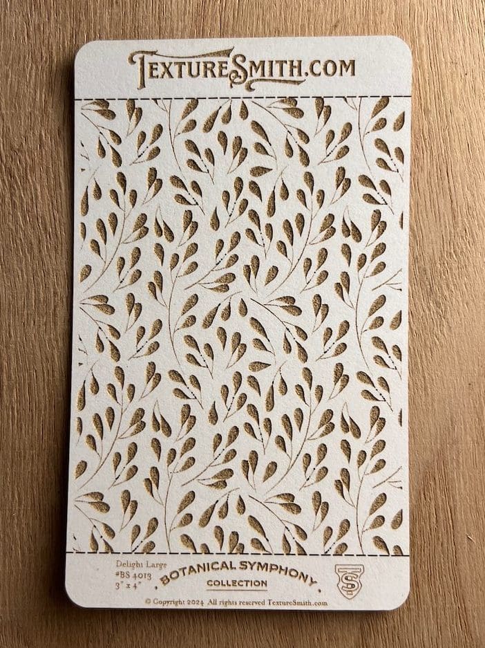 Decorative wallpaper with gold leaf patterns on a white background.