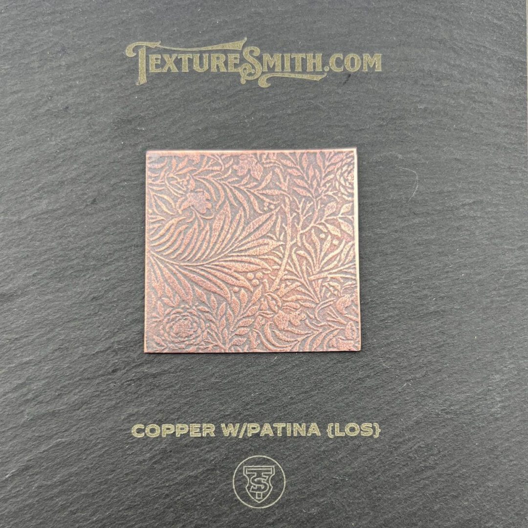 A copper square plate with intricate geometric patterns.