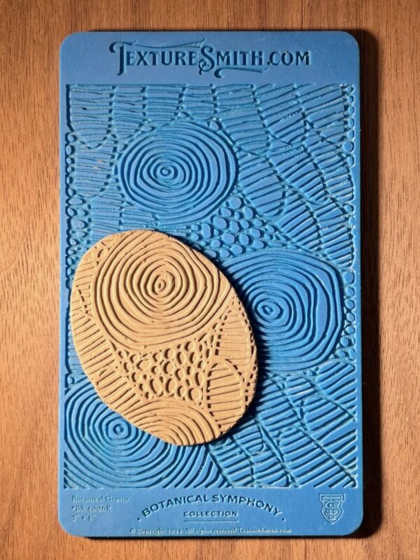 Textured blue mat with beige patterned clay