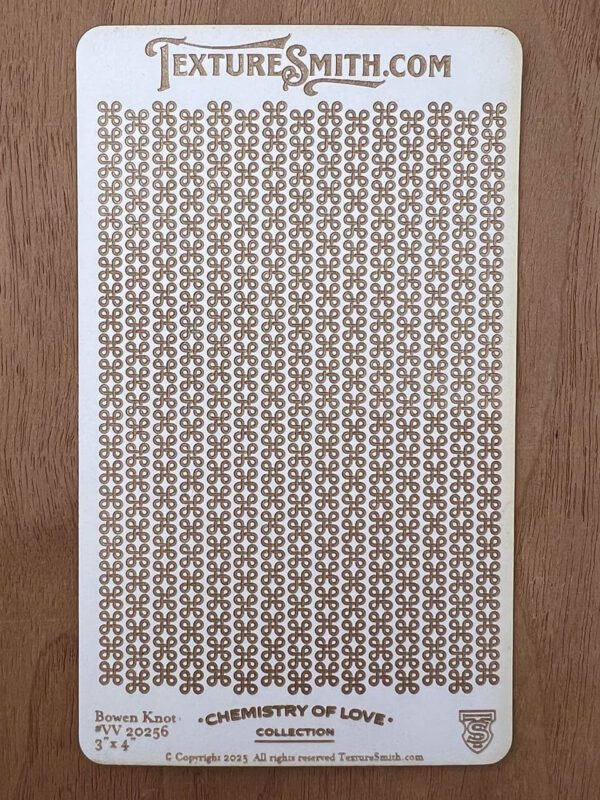 A sheet of paper with a repetitive floral pattern placed on a wooden surface.