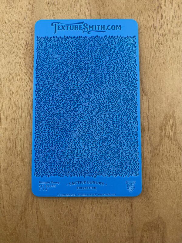 Blue textured silicone phone case on a wooden surface.