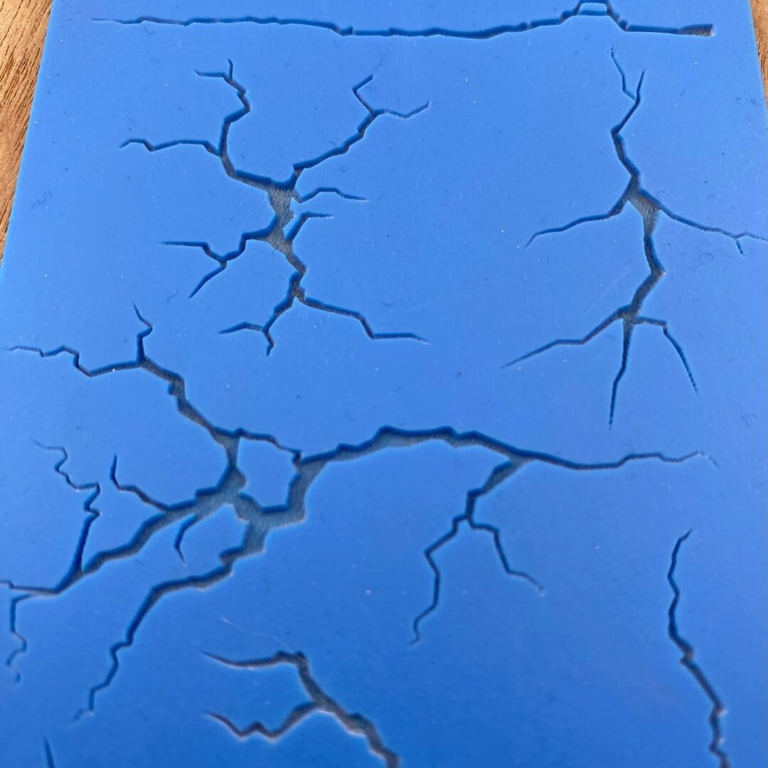 Blue surface with black cracks forming a unique pattern.