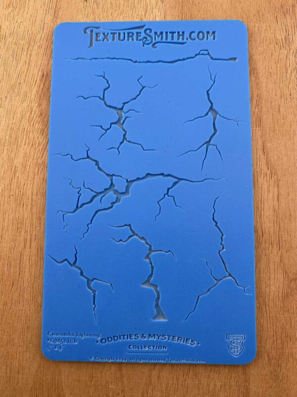 Blue surface with multiple black crack-like patterns.