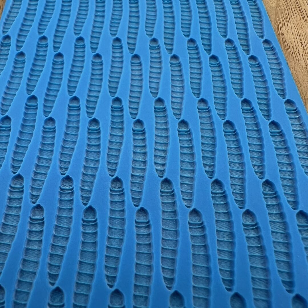 Close-up of a textured blue foam mat with a wavy pattern.