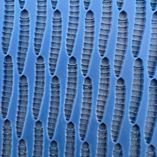 Close-up of blue textured surface with repeating elongated oval shapes.