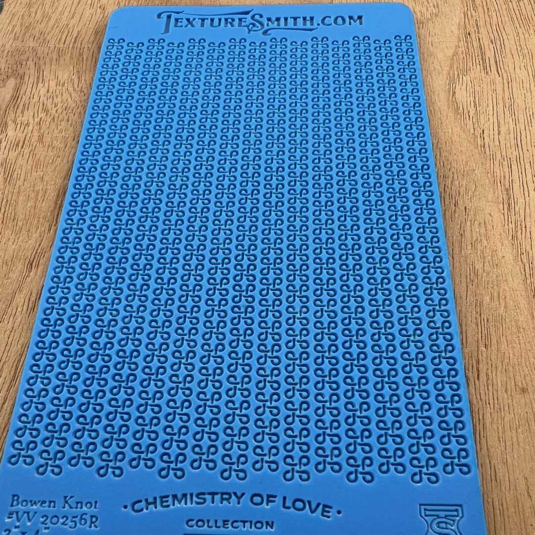 Blue stencil with uppercase letters and numbers for crafting or lettering.