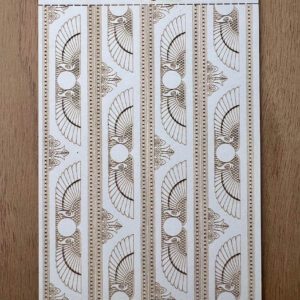 Decorative white molding strips with intricate patterns on a wooden surface.