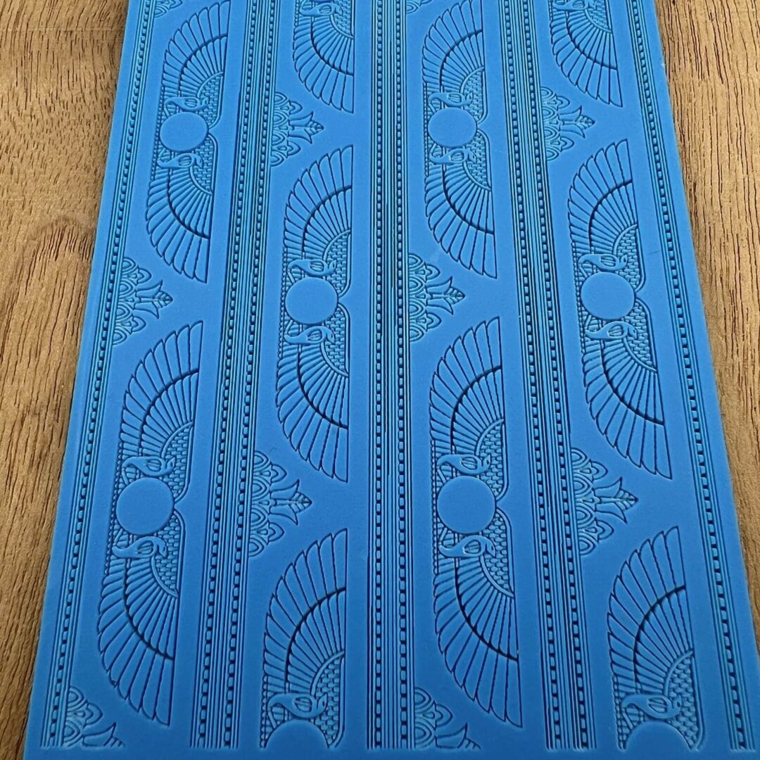 Blue mat with intricate perforated patterns and designs.