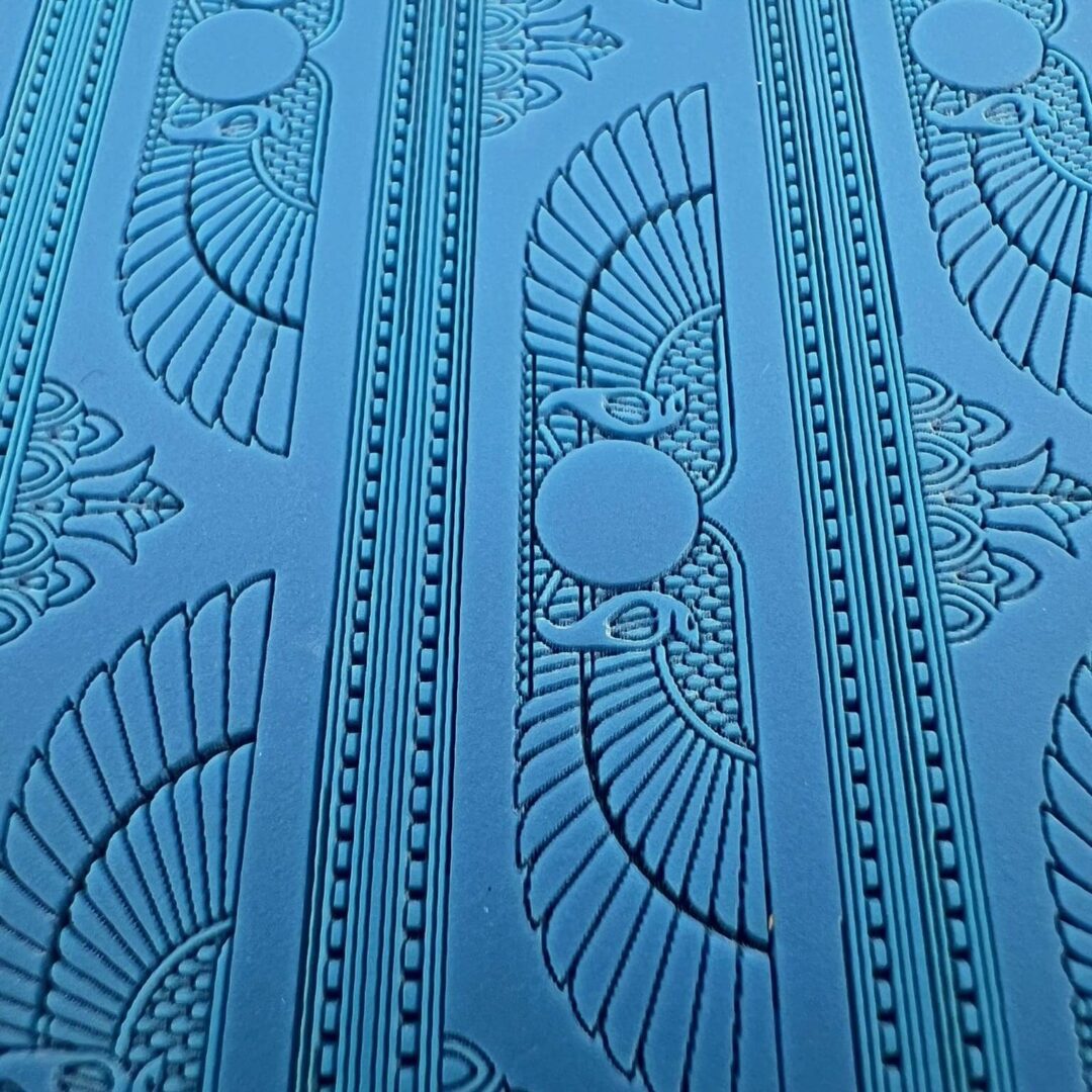 Intricate blue textured pattern with fan and circular designs.