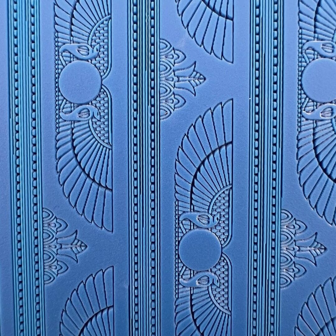 Blue wall with Egyptian-inspired winged sun and lotus motifs.