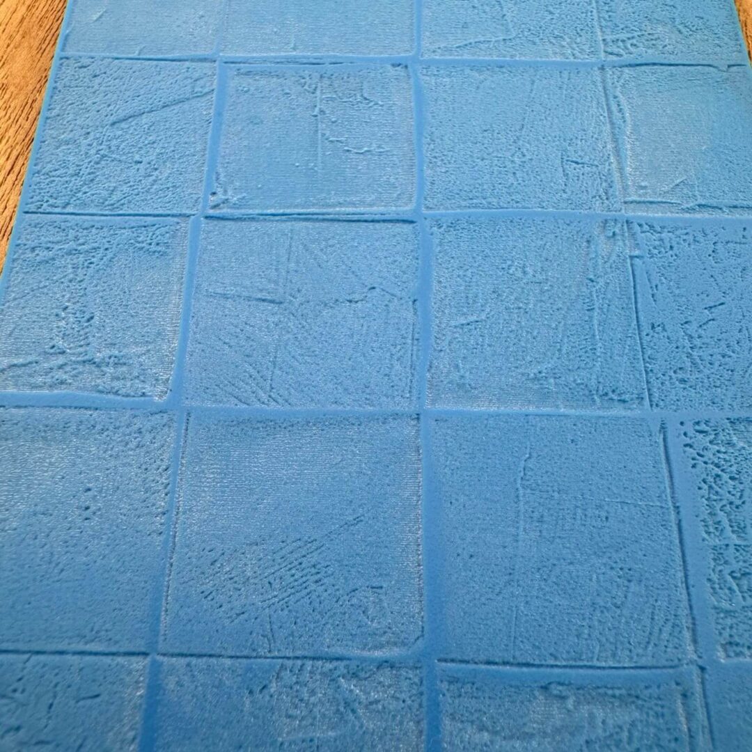 Blue textured square tiles arranged in a grid pattern.