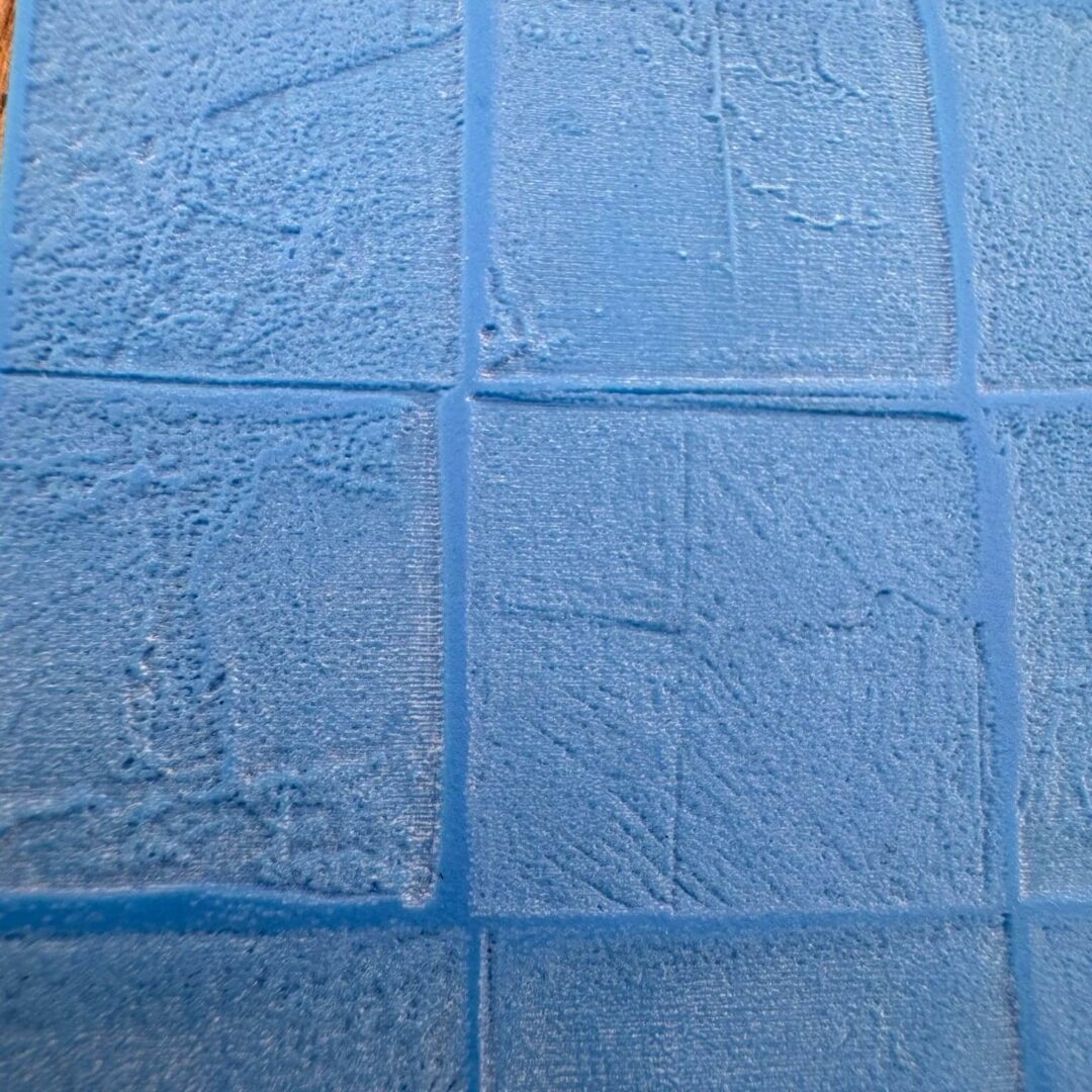 Close-up of textured blue tiles arranged in a grid pattern.