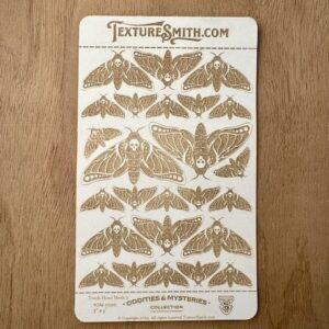 Wooden board engraved with detailed moth illustrations and names.