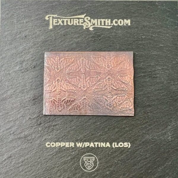 Rectangular copper plate with patina and intricate geometric patterns.