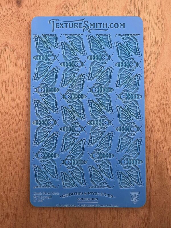 Blue stencil sheet with leaf patterns arranged in rows.