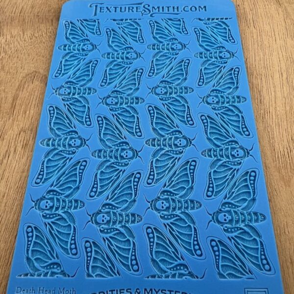 Blue stencil sheet with repeating butterfly wing patterns.