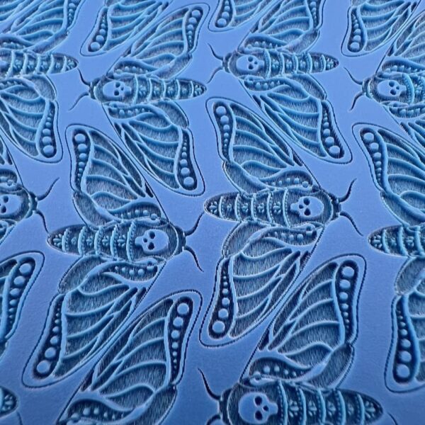 Blue fabric with intricate butterfly and leaf patterns.