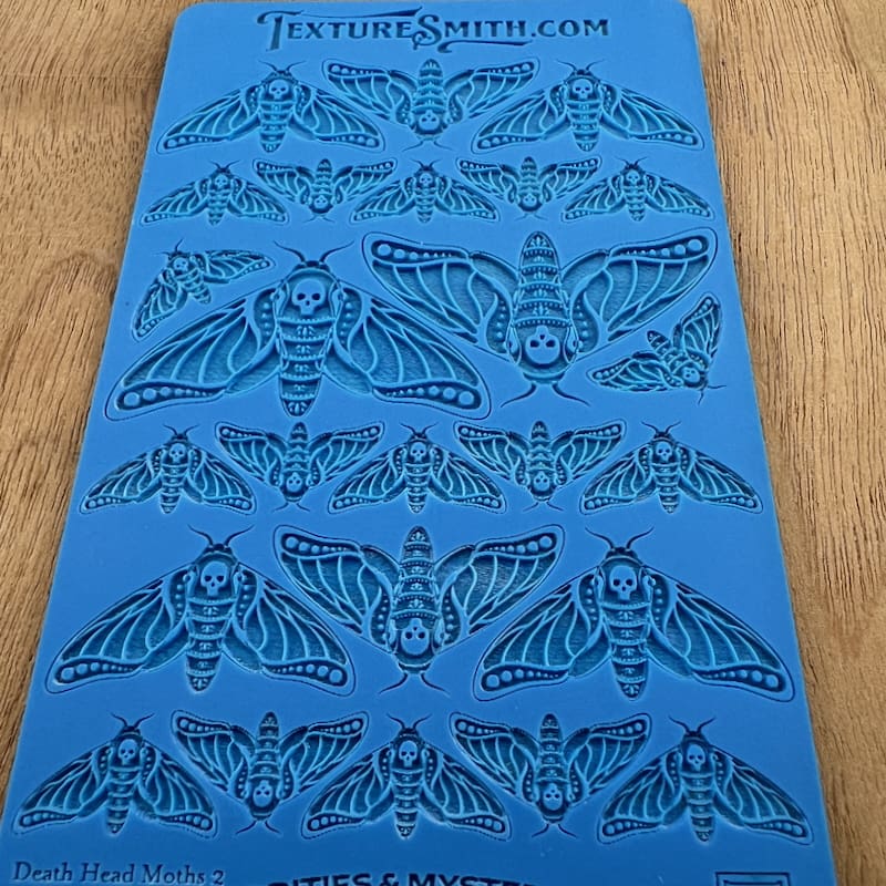 Blue stencil sheet featuring various moth and butterfly designs.