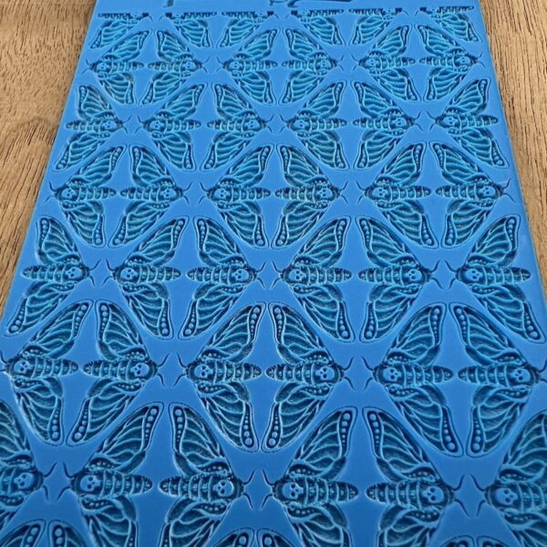 Blue fabric with intricate butterfly and floral patterns.