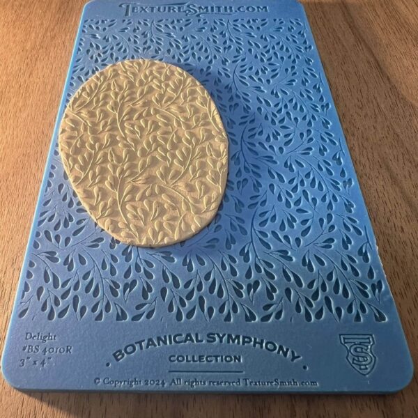 A blue botanical-themed tray with a textured round sponge on it.