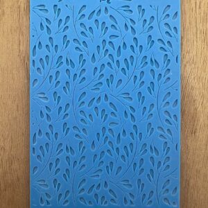 Blue notebook with an abstract leaf pattern on a wooden surface.