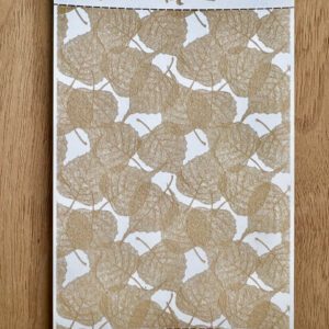 A decorative beige and white patterned fabric or paper on a wooden surface.