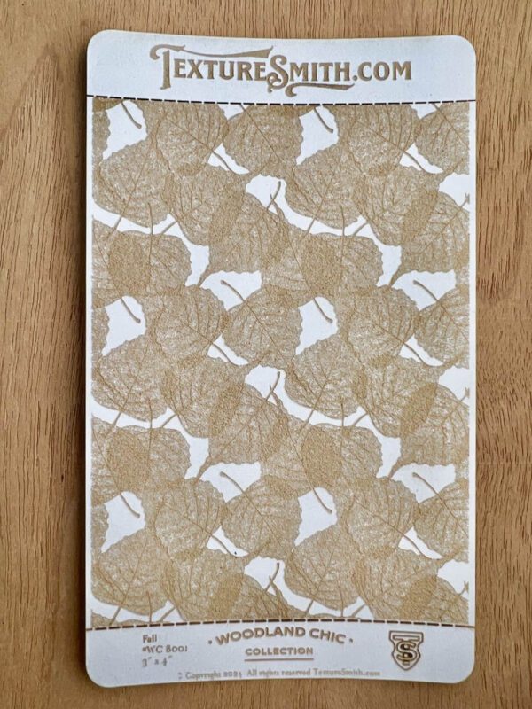 A decorative beige and white patterned fabric or paper on a wooden surface.