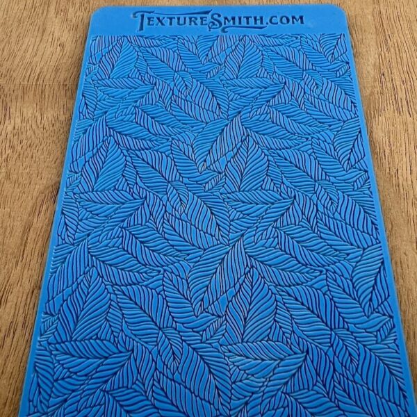 Blue textured mat with intricate leaf patterns.